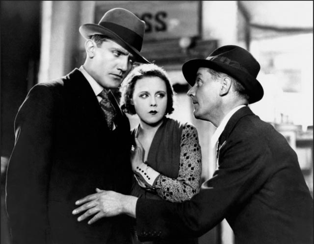 Tracy (Donald Calthrop) attempts to blackmail Alice and her policeman boyfriend Frank (John Longden) in Alfred Hitchcock's Blackmail (1929)