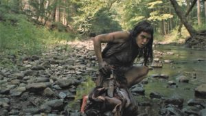 The woman (Pollyanna McIntosh) cleans her wounds in a stream in Lucky McKee's The Woman (2011)