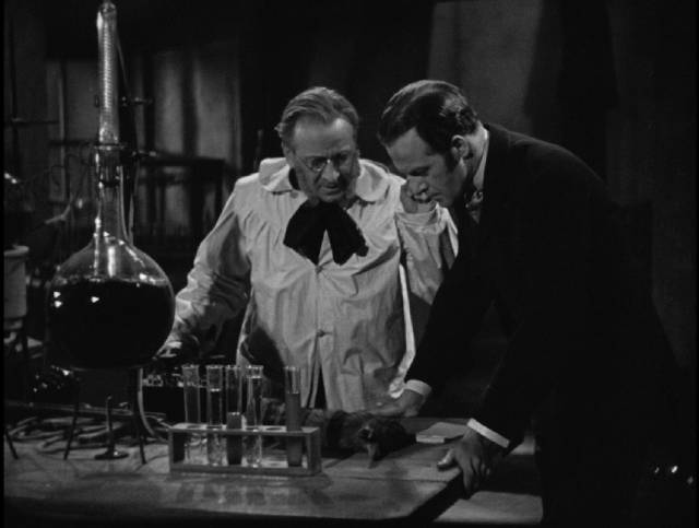 Professor Le Blanc (Wallace Evennett) and Lucien Cortier (John Warwick) watch electricity revive dead tissue in George King's The Face in the Window (1939)