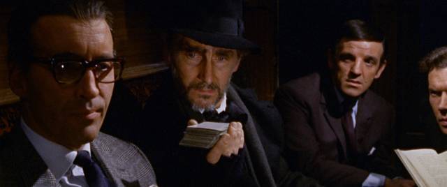 A mysterious stranger (Peter Cushing) invites Franklyn Marsh (Christopher Lee) to draw a card in Freddie Francis' Dr. Terror's House of Horrors (1965)