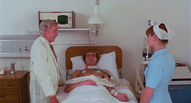 Dr. Roget (Robert Helpmann) explains the case to Nurse Jacquard (Susan Penhaligon) in Richard Franklin's Patrick (1978)