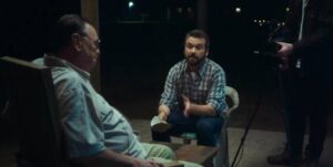 Sam Turner (AJ Bowen) conducts a confrontational public interview with Father (Gene Jones) in Ti West's The Sacrament (2013)